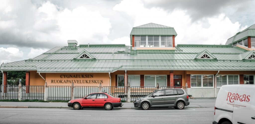 Cygnaeuksen ruokapalvelukeskusrakennus ja kaksi autoa