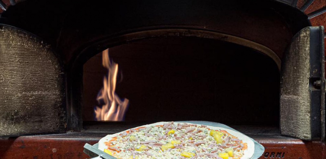 Rosso, pizza going into the oven