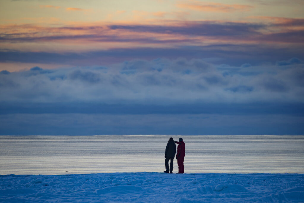 Kaksi ihmistä katsomassa merelle talvisessa Yyterissä