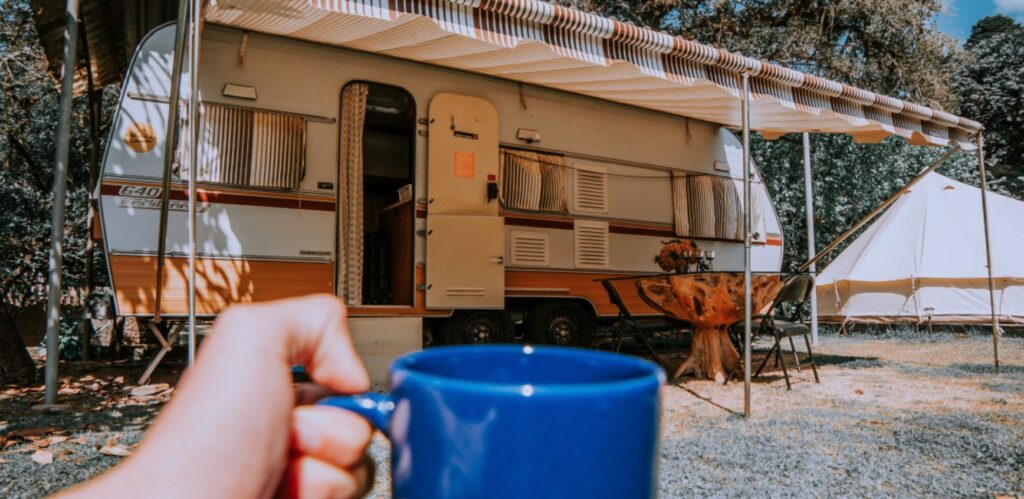 Asuntovaunun ja edustalla sininen kahvikuppi