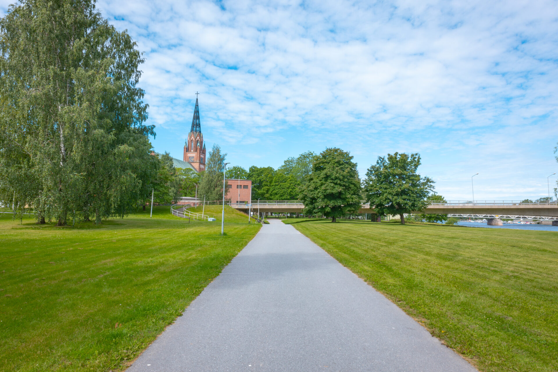 asfalttitie joka menee sillan alta, taustalla korkea kirkkorakennus