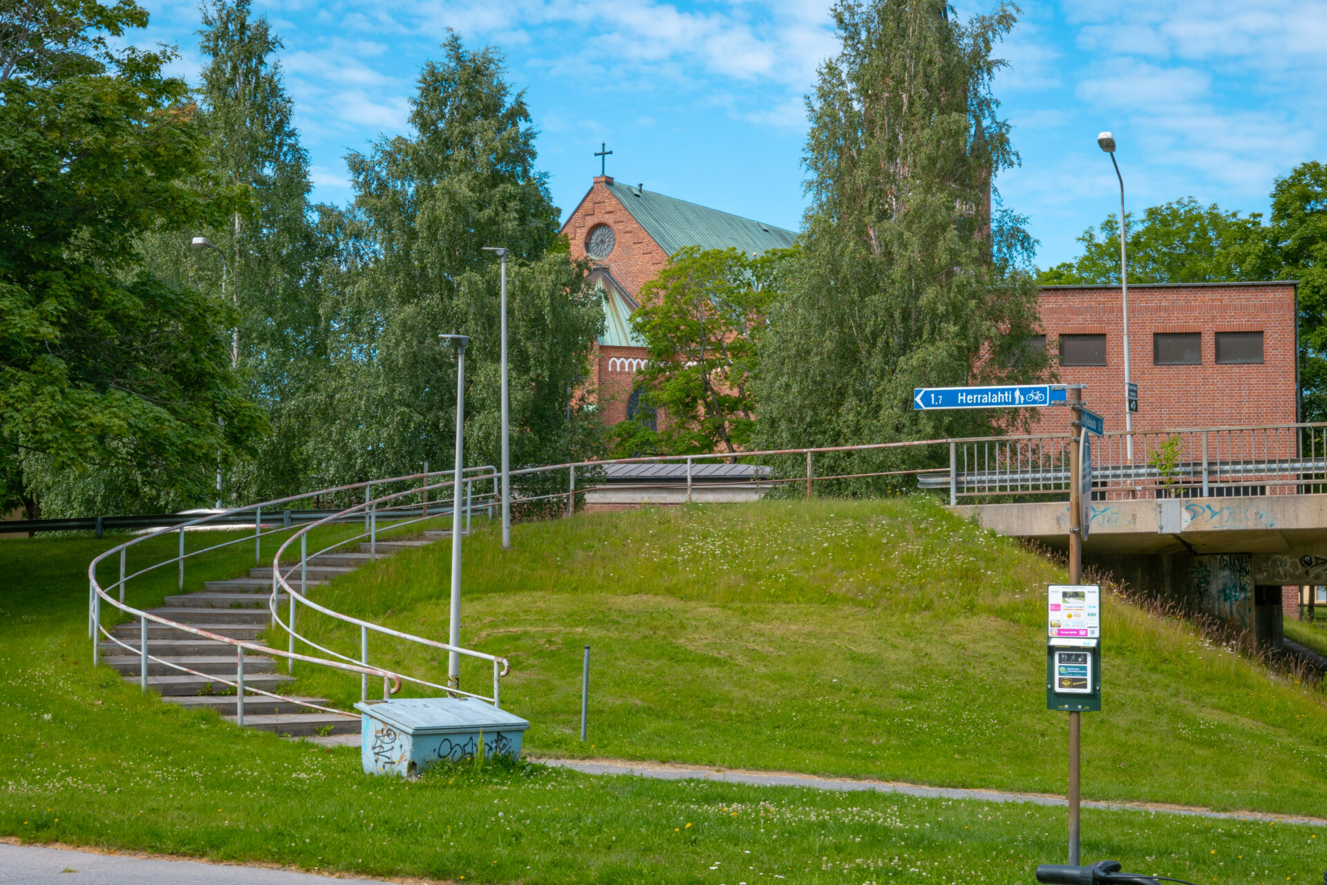 portaat sillalta alikulkuun, taustalla kirkko jonka edessä puita