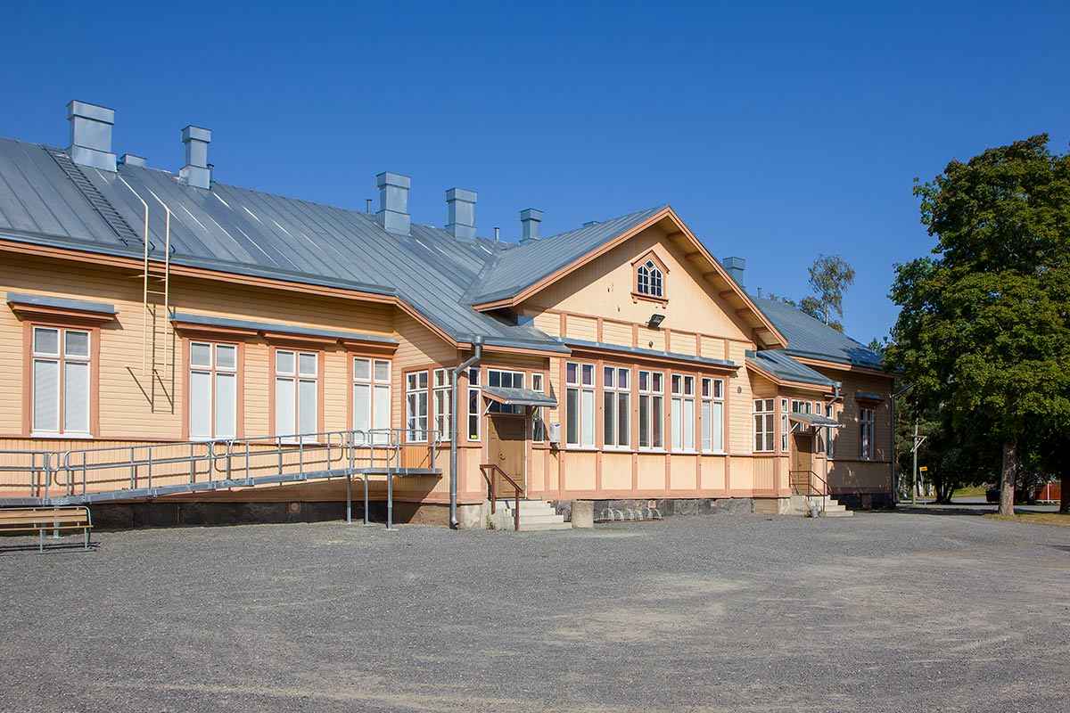 puinen rakennus jossa kaksi ulko-ovea, toisen oven vieressä pyörätuoliluiska