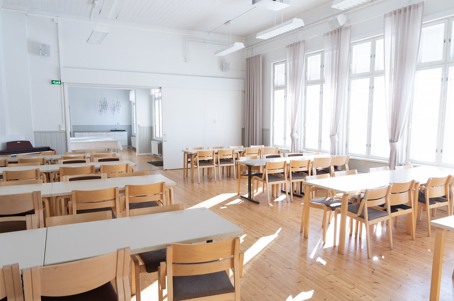 juhlatila, jossa pöytiä tuoleineen