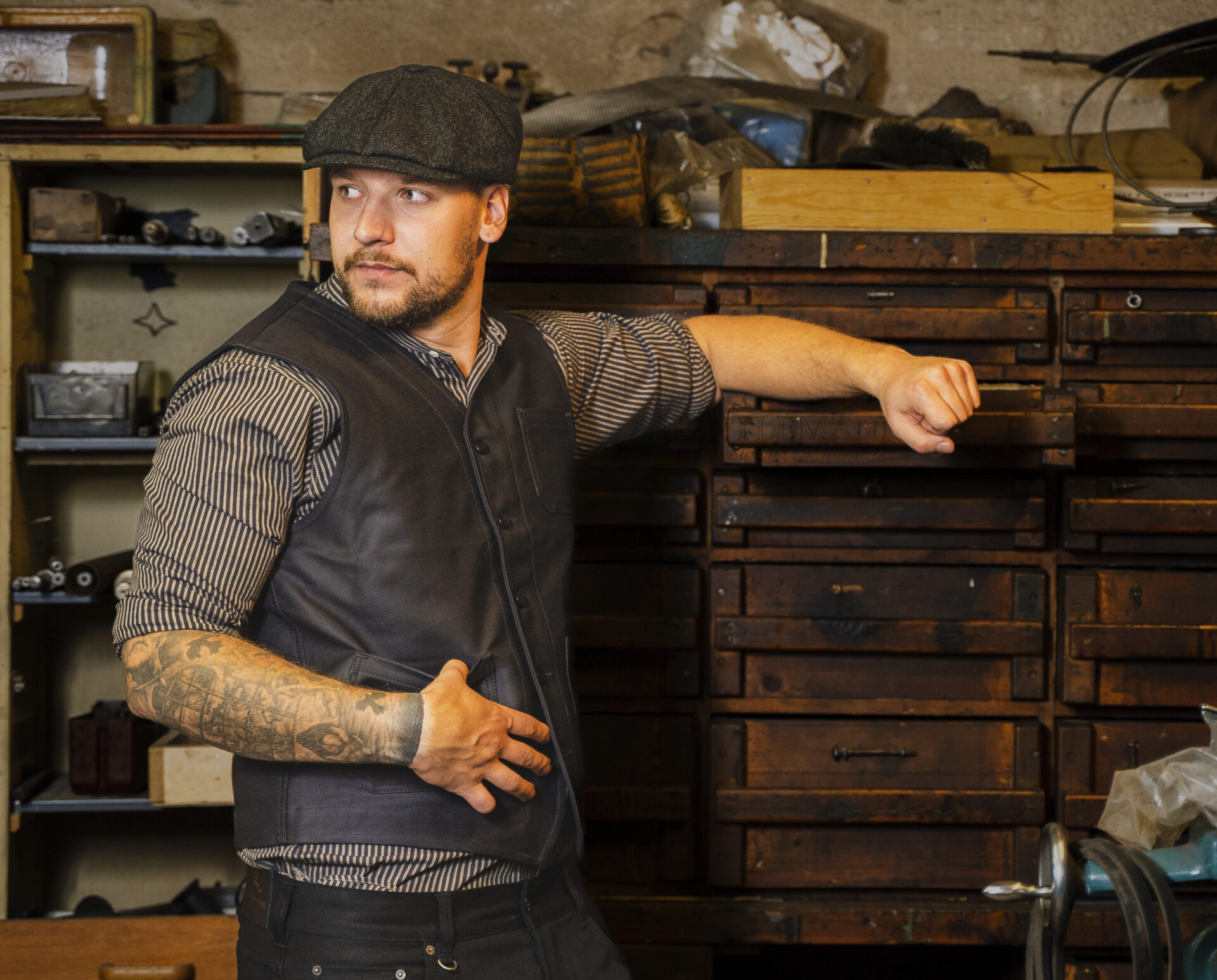 Gentlemanni: gentleman leans against a box in a vest and hat.