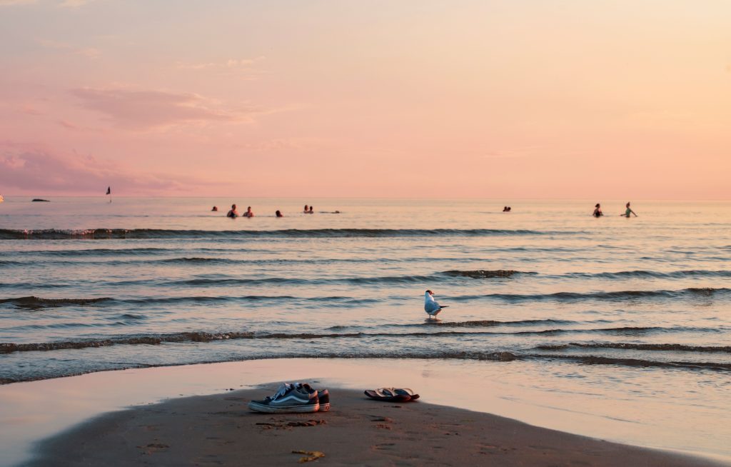 Ihmisiä uimassa meressä Yyterissä auringonlaskun aikaan