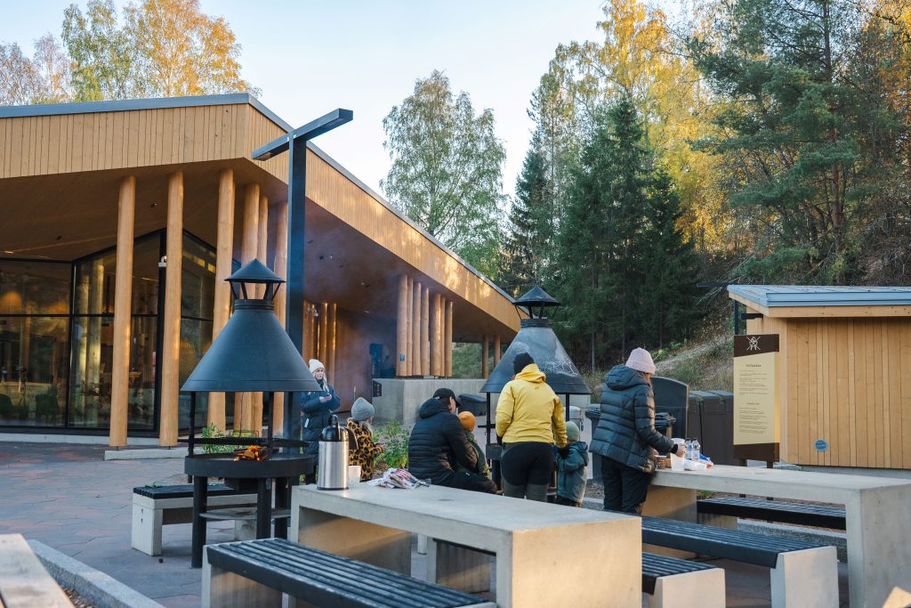Ihmisiä grillaamassa Yyterin vierailukeskuksen pihan grillipaikalla