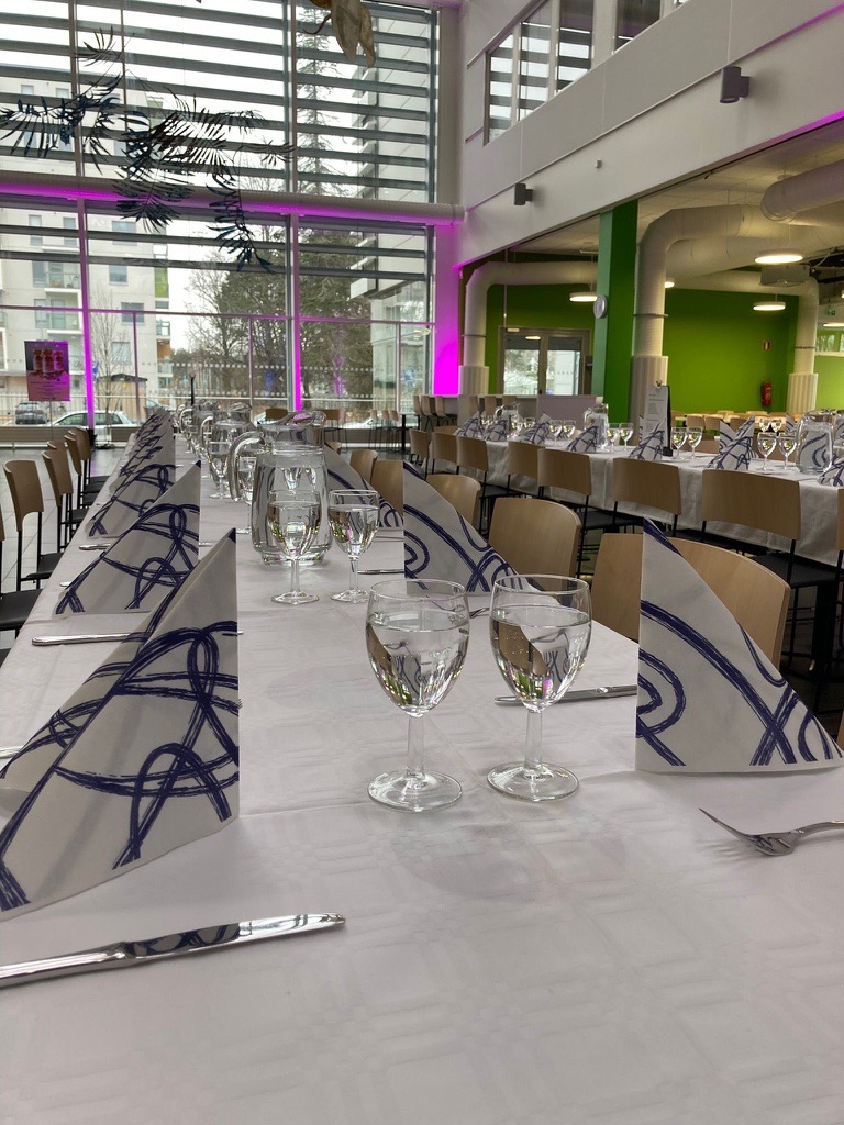 Ravintola Silvia_pitkät pöydät valmiiksi katettuna ja vesilasit täytettyinä.