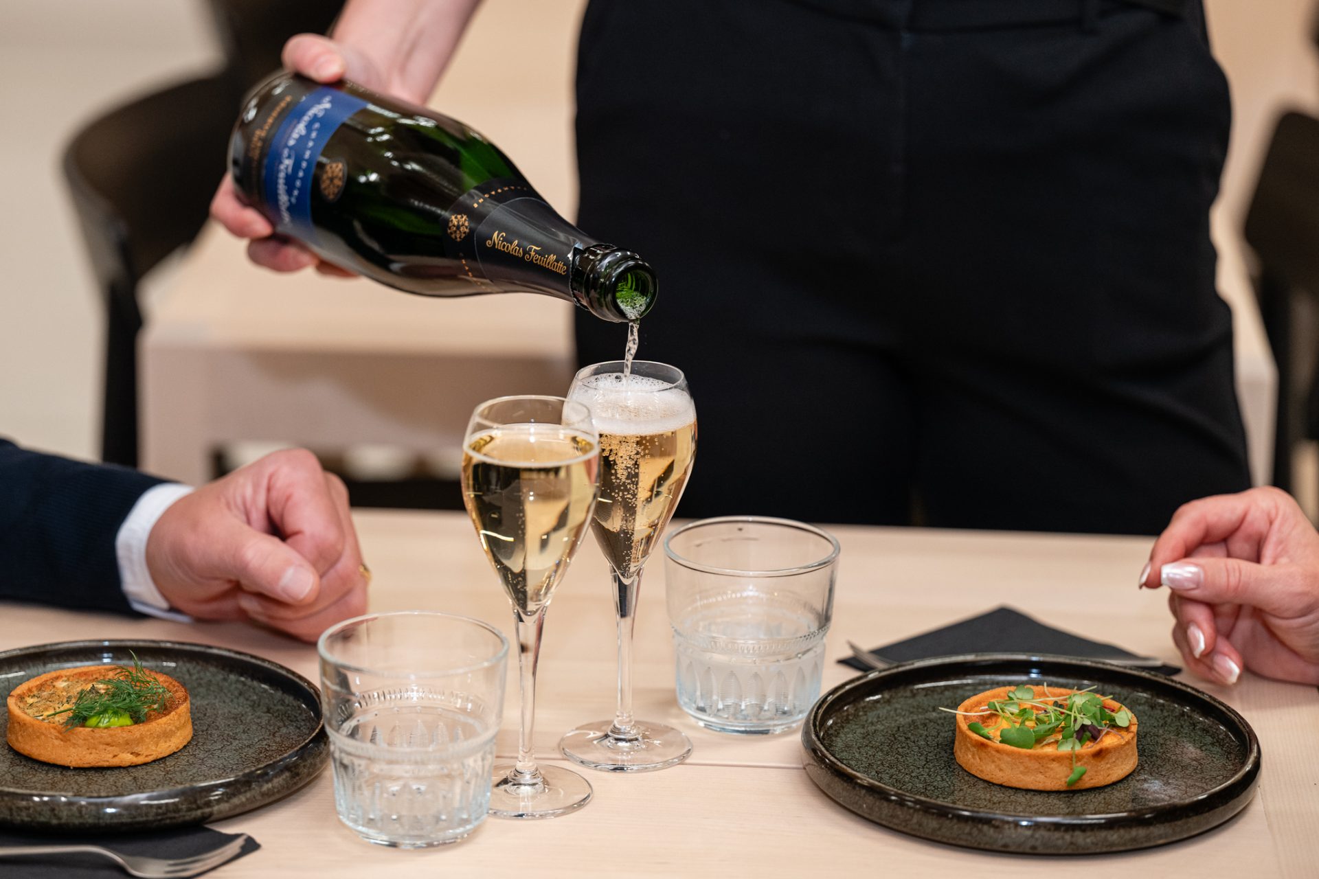 Blåbärin pöytään tarjoillaan kuohuvaa ja suolaiset piirakat.