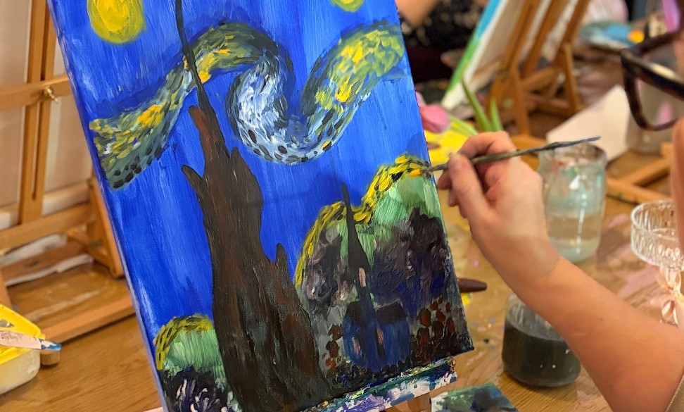 Luavaamossa henkilö maalaa omaa taidetaan.