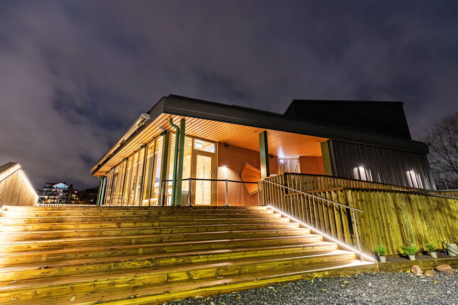 Rauha Sauna & Loungen rakennus ulkoa pimeällä valaistuna.