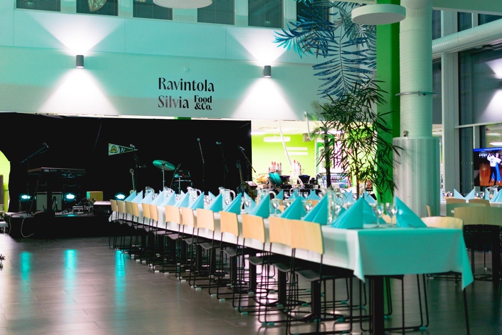 Ravintola Silvian pitkä pöytä katettuna iltavalaistuksessa.