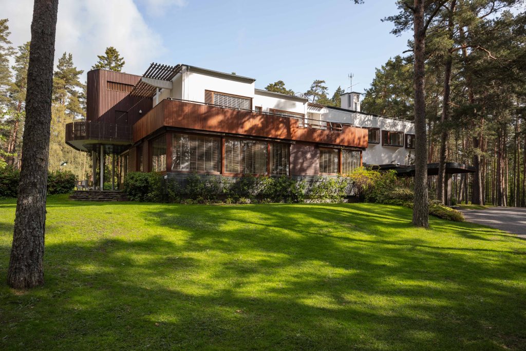 The exterior of Villa Mairea, partially shaded by pine trees.