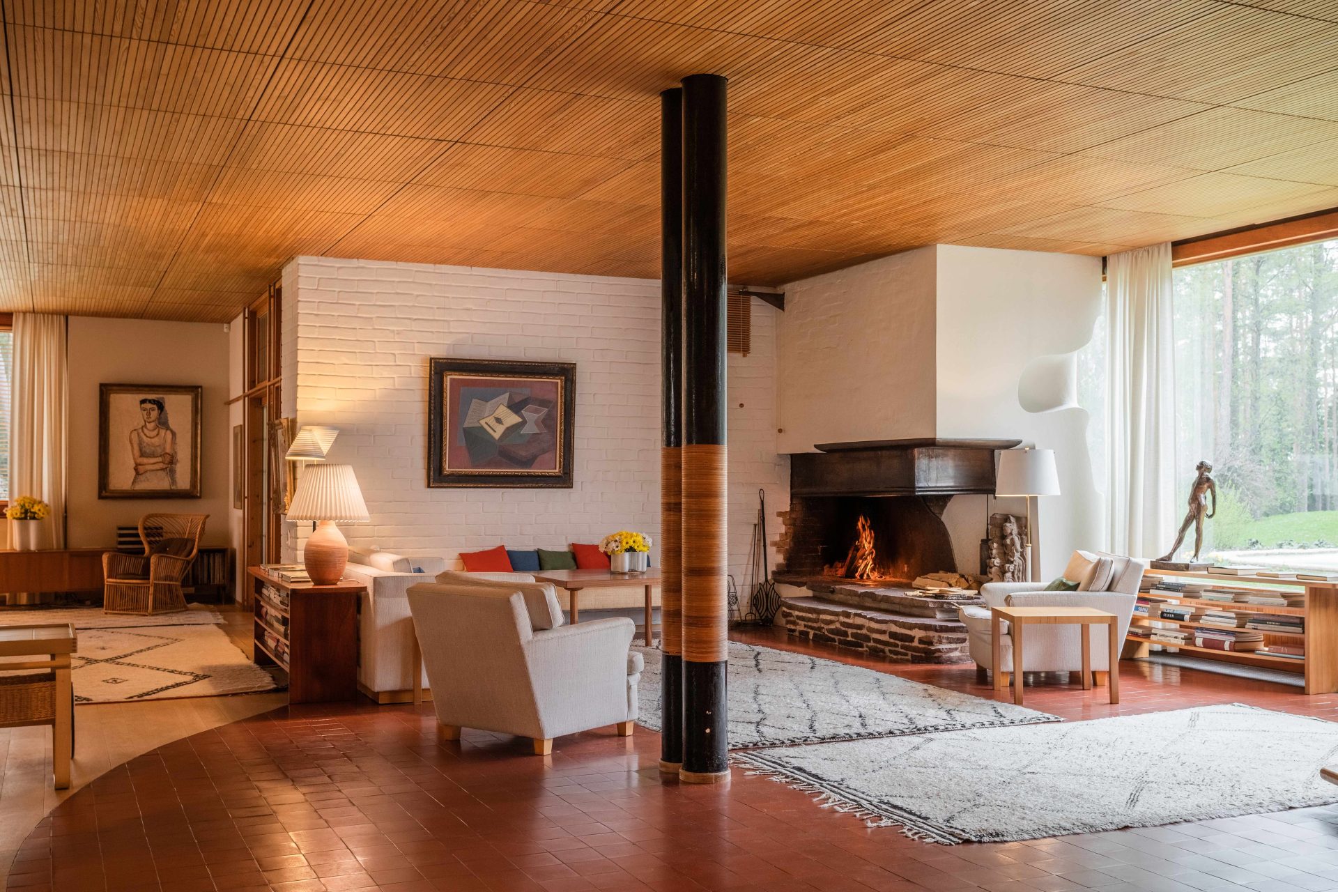 The living room of Villa Mairea, with a fire burning in the open fireplace.