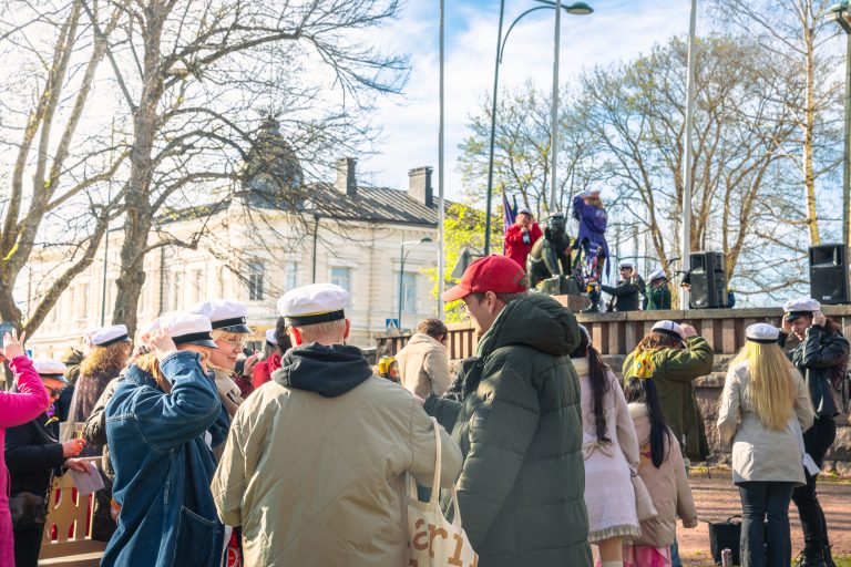 Ylioppilaslakkipäisiä ihmisiä vappua viettämässä. Karhunlakitus Raatihuoneenpuistossa.