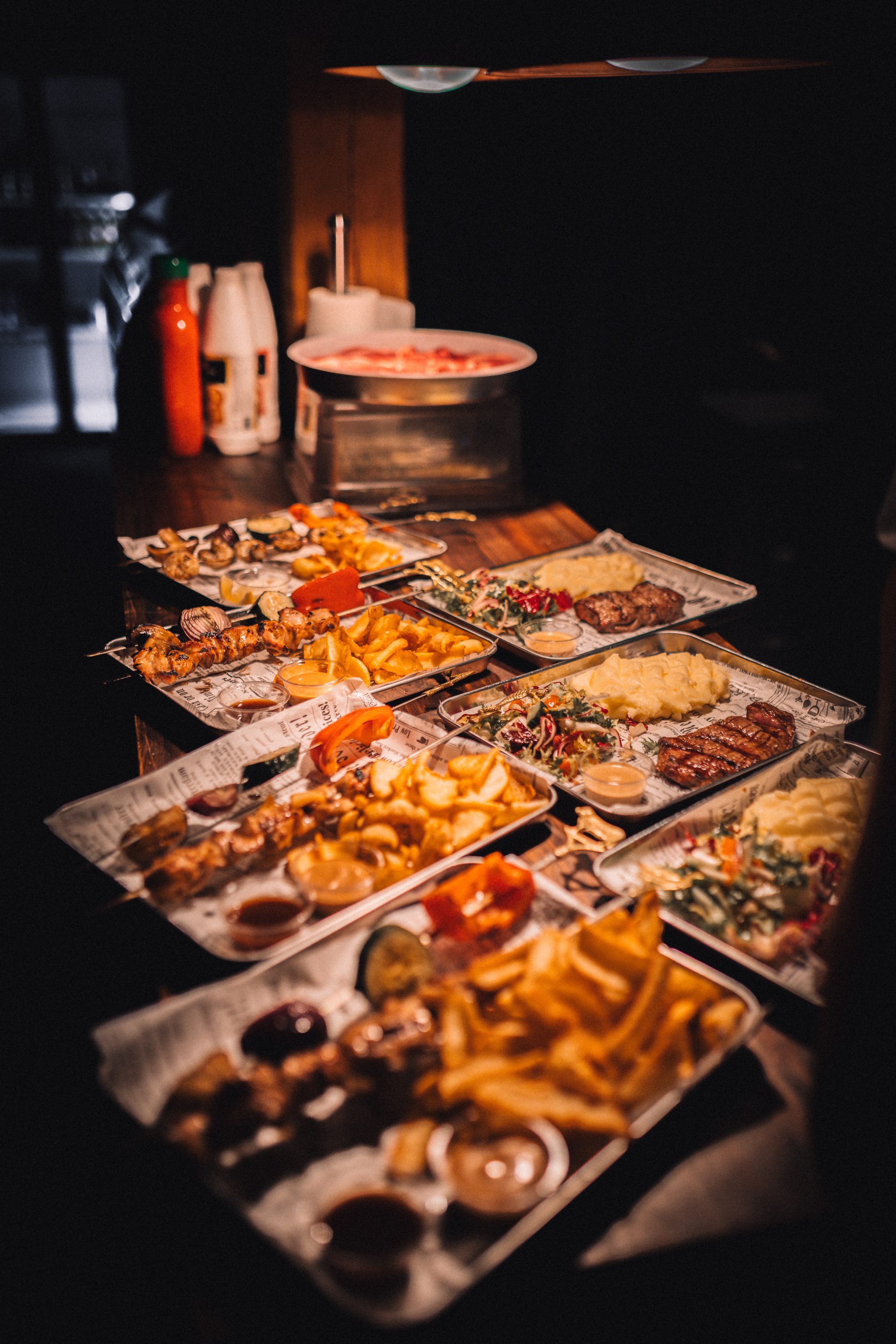 Cowboys Grill & BBQ ruoka-annoksina lihavartaita ja pihvejä pöydällä esillä.