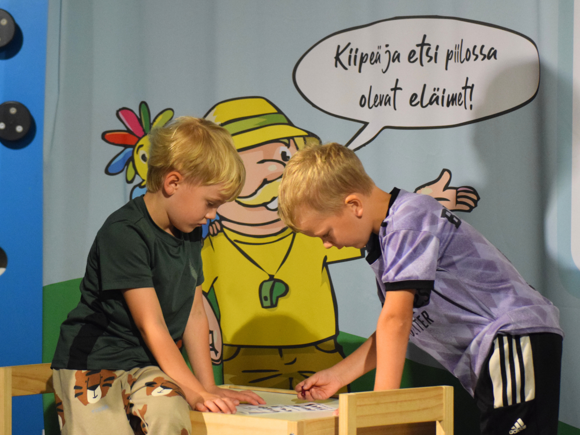 Irti Maasta kiipeilyseikkalun osallistujia tutkimassa tehtävää.